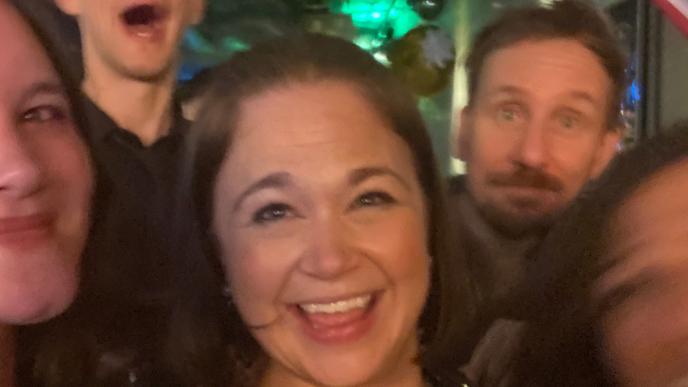 A woman at the front of a group of people at a party.
