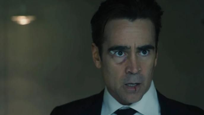 Colin Farrell in a suit with a bandage by his eye and a bloody lip