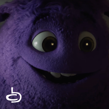 A purple furry monster smiling at something offscreen, the logo for Cartoon Brew is in the lower left corner.