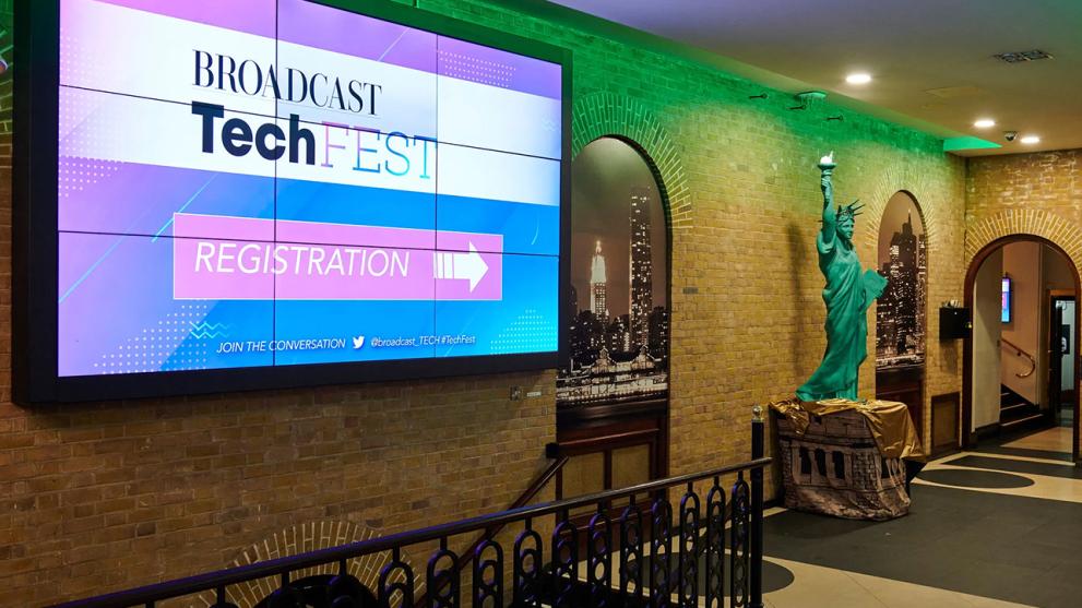 A hallway with large LED screen that reads "Broadcast Tech Fest Registration"