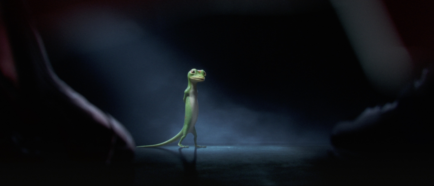 animated geico mascot walking with its hands behind its back