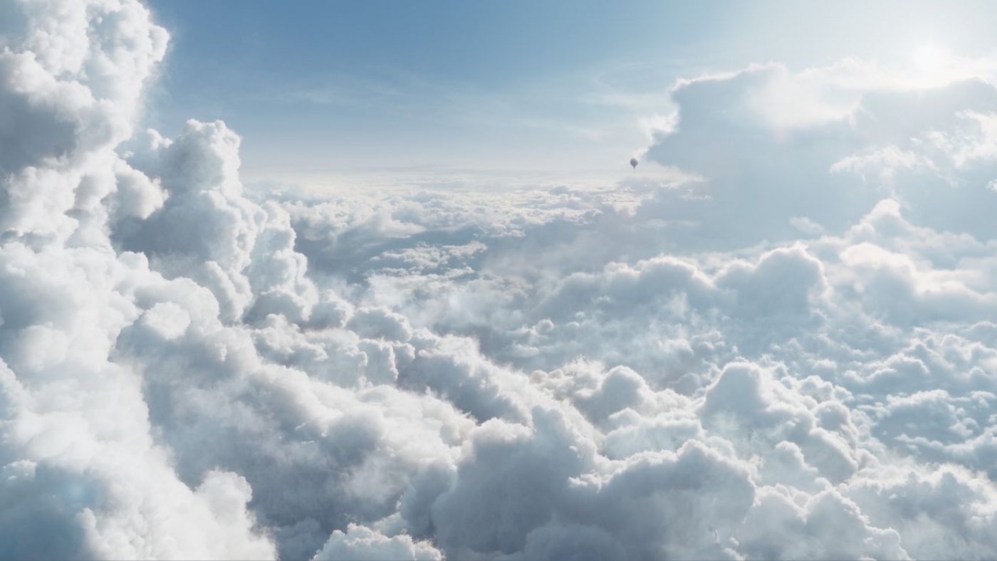 a bright and sunny blanket of clouds in the troposphere as a hot air balloon flies in the distance