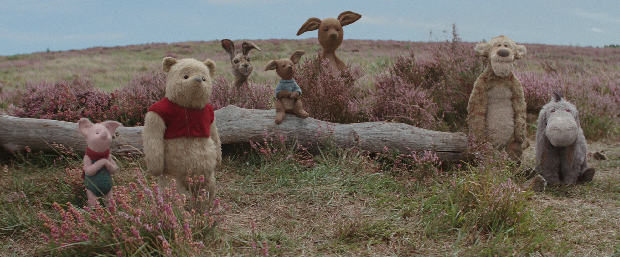 Pooh and friends sit on a log