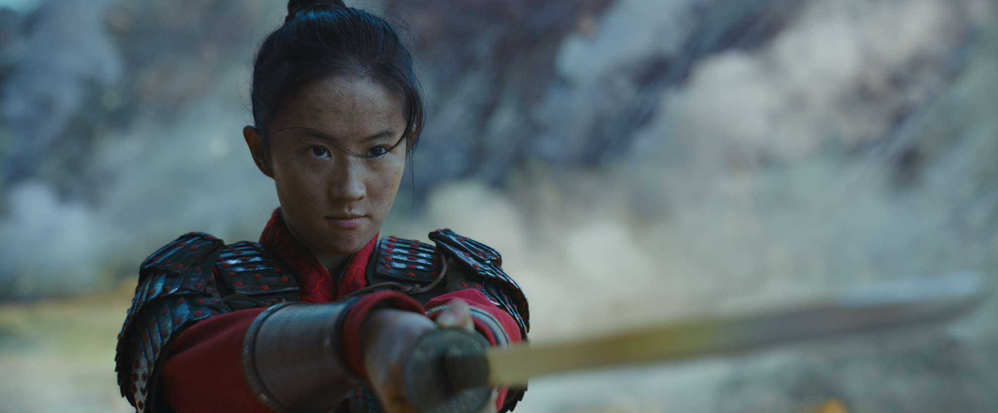 Mulan wearing armour, pointing a sword toward the camera