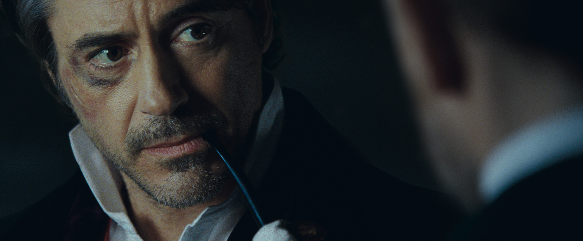 Robert Downey Junior as Sherlock Holmes, with a black eye and a pipe in his mouth