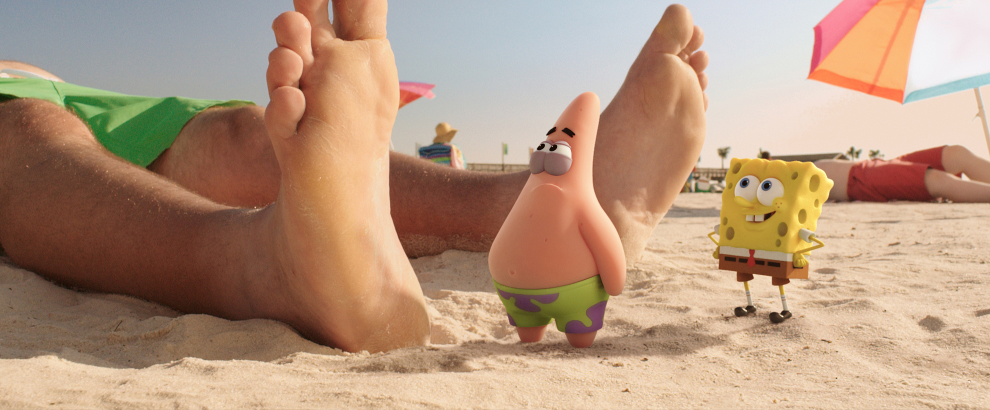 Spongebob and Patrick stand on the shore of a beach, looking at a large human foot