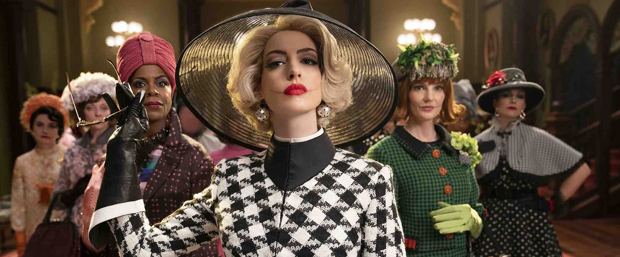 Anne Hathaway in a black and white houndstooth suit, leads the ensemble cast of The Witches