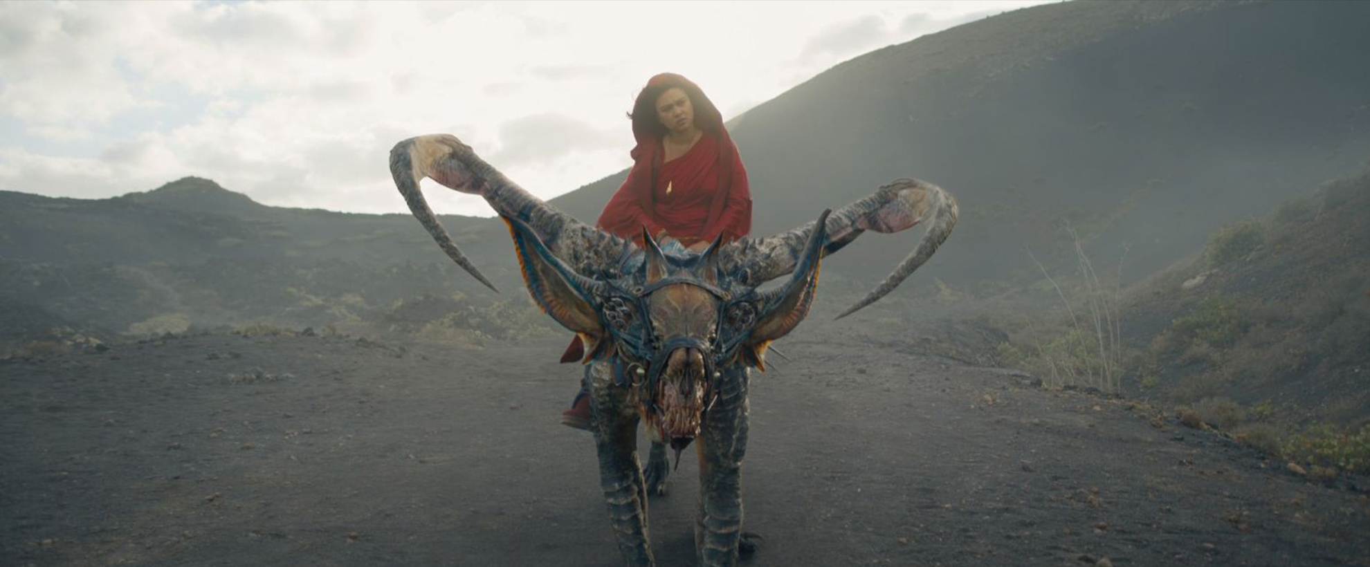 A young woman in a red dress riding an alien creature