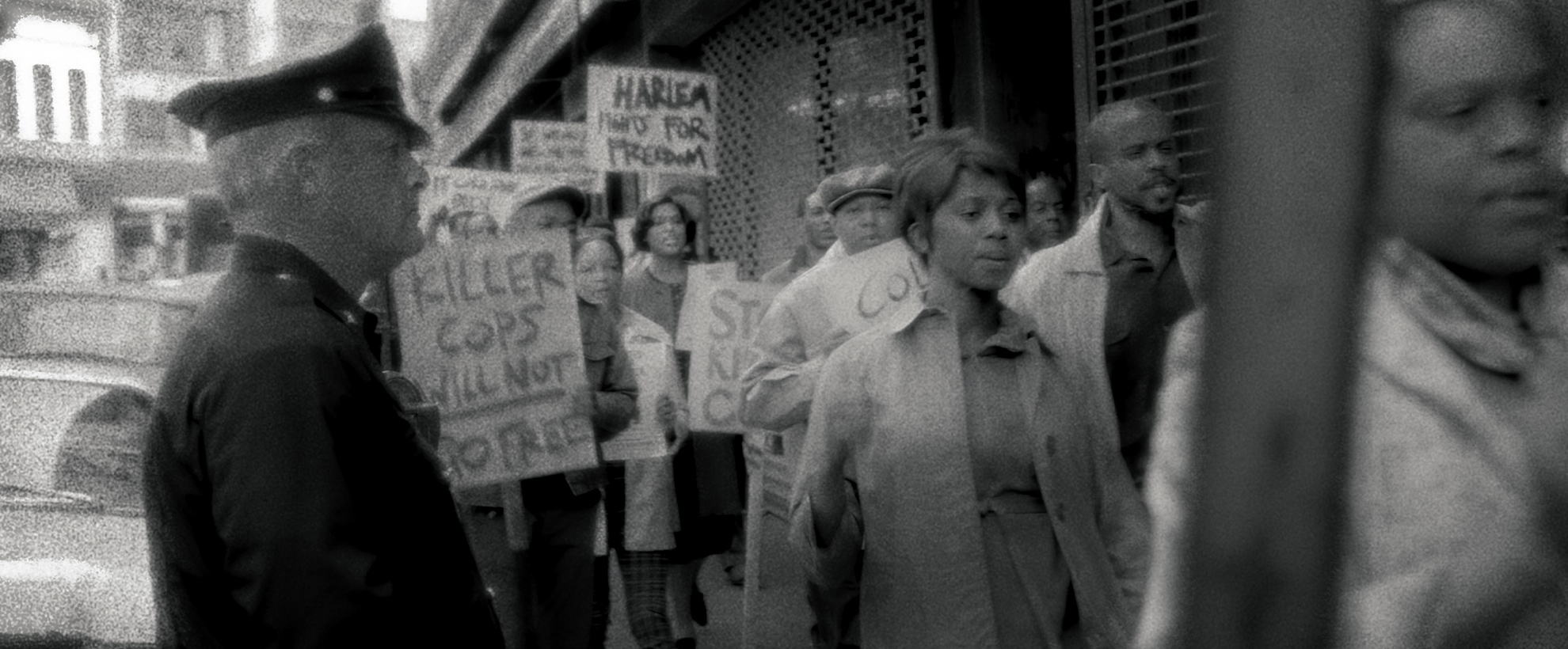 Grainy black and white footage of women protesting