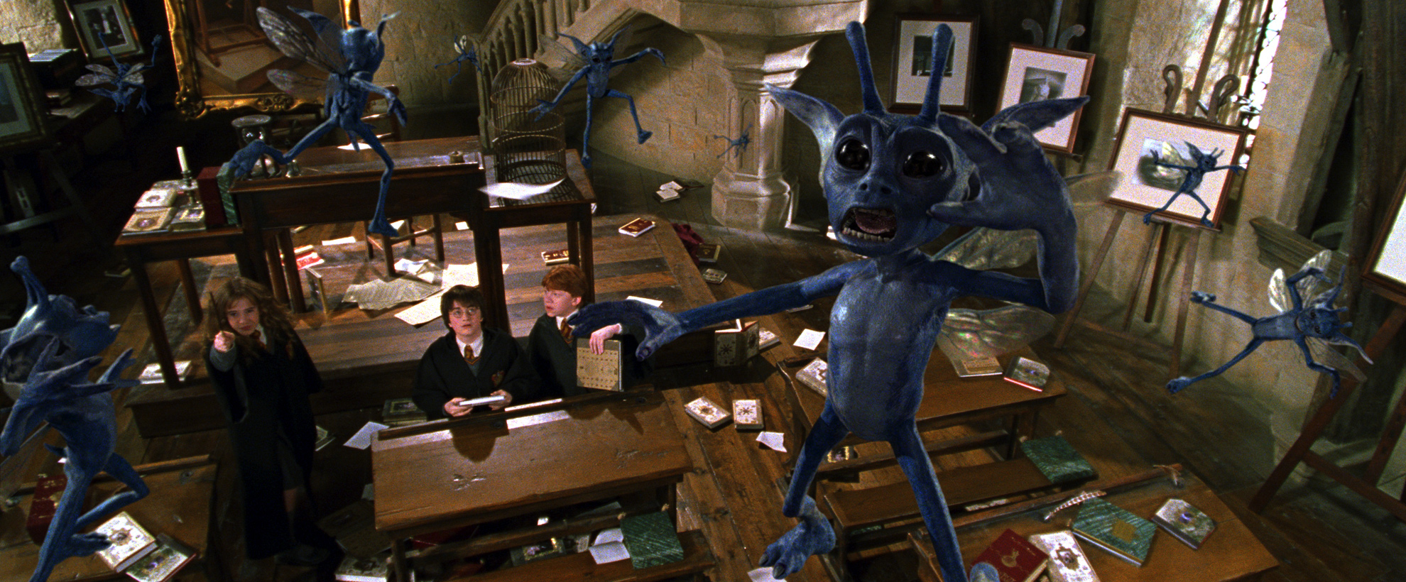 A scene from the Chamber of Secrets. Hermione, Harry and Ron are in a classroom surrounded by dazed, blue pixies