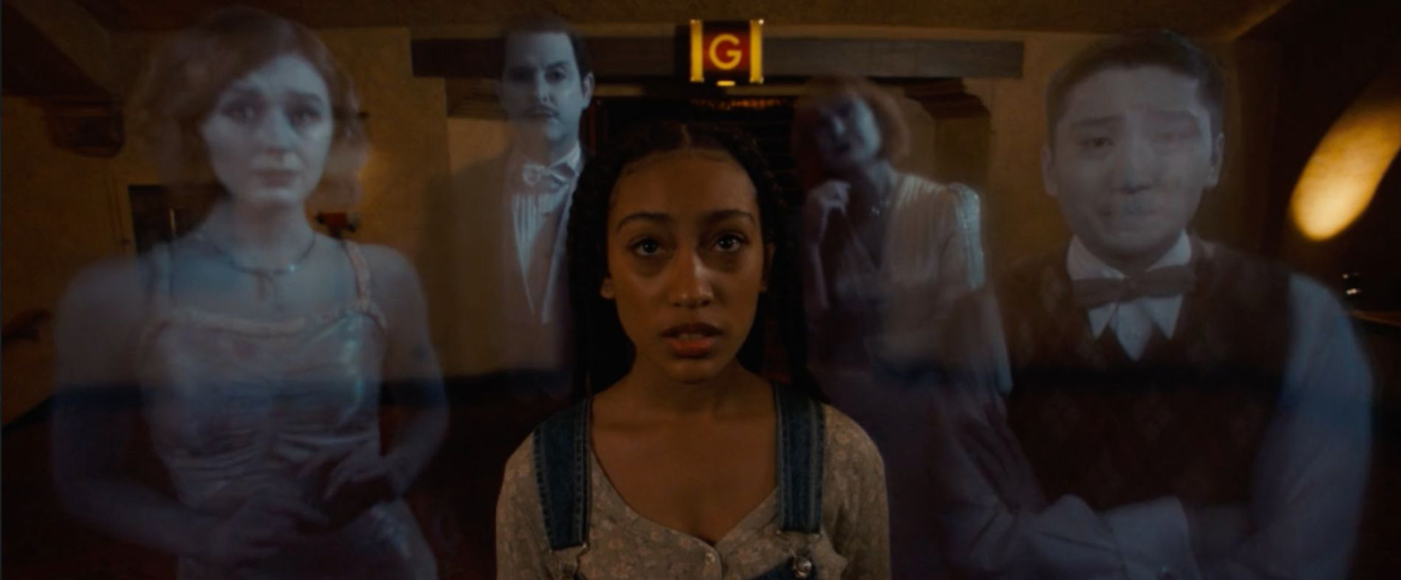 A young black woman in a hallway, surrounded by 4 ghosts