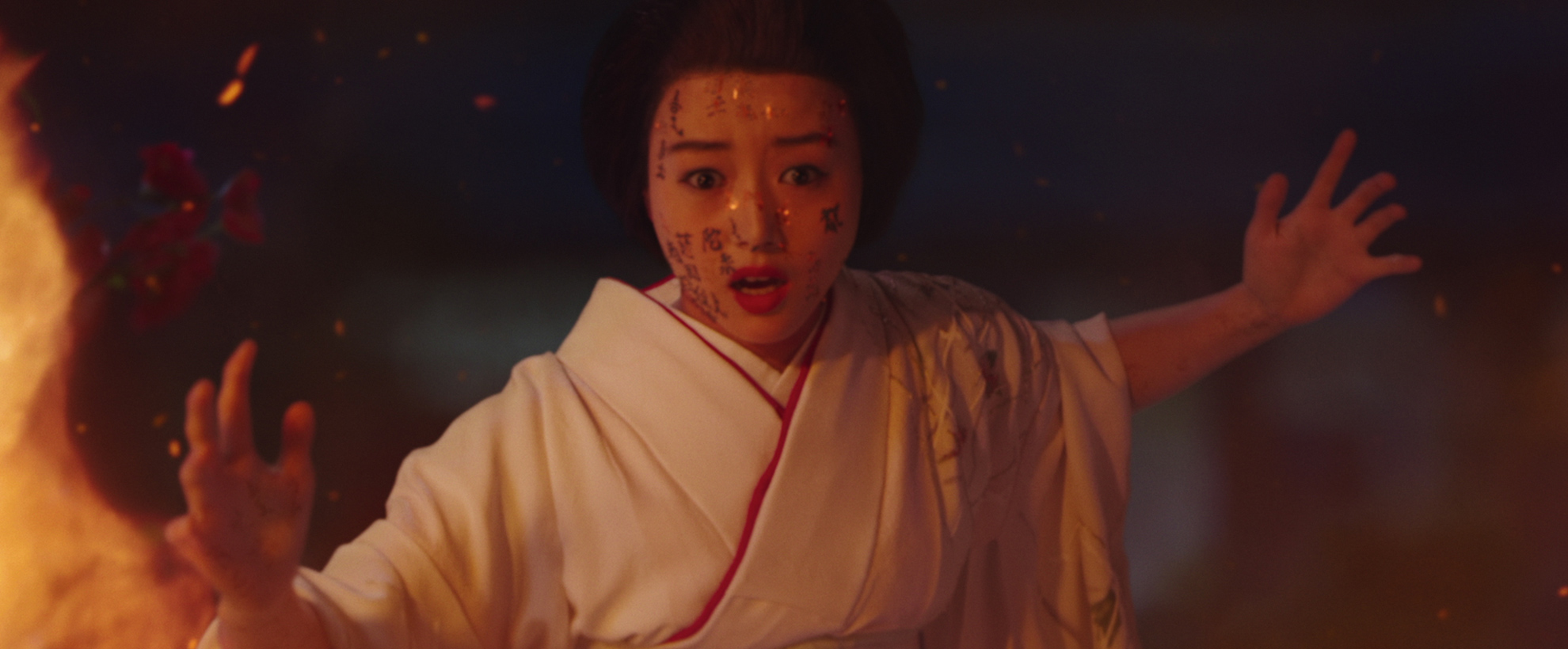 A young asian woman in a white robe, she has multiple small wounds on her face