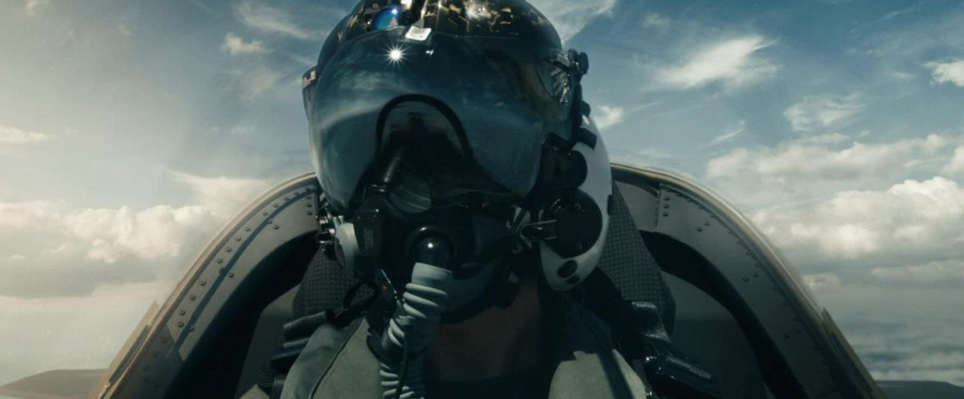 A US military pilot sits in the cockpit of a jet with a helmet on