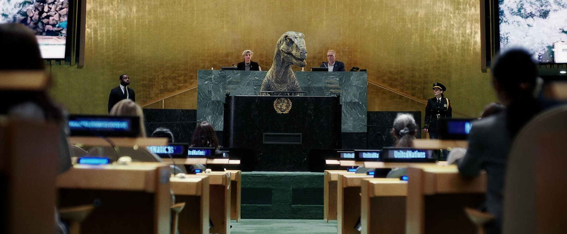 A United Nations panel with multiple people at desks with headsets, there is a velociraptor at the front of the room at a lecturn.
