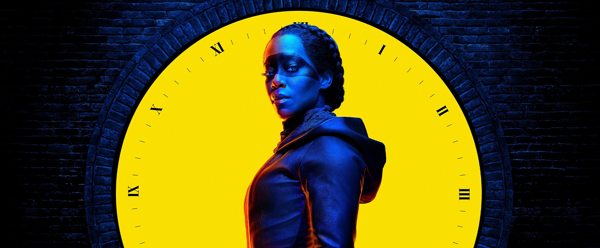 A promotional image of Regina King in Watchmen, in navy light against a bright yellow clock