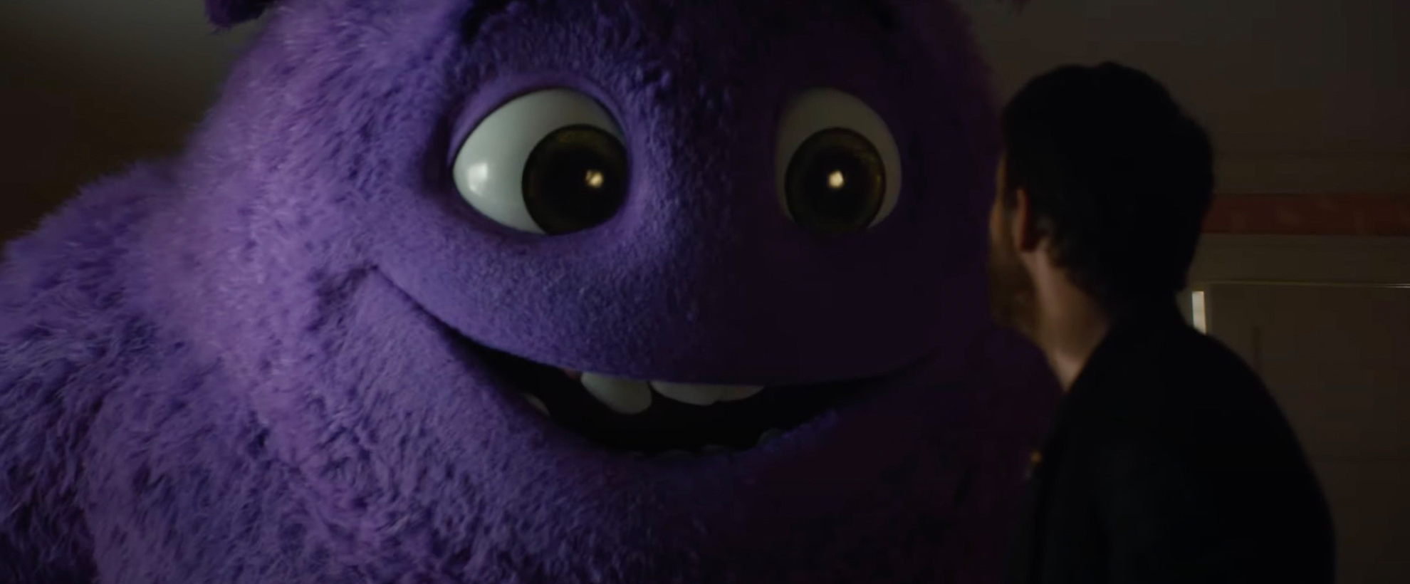 A large purple fluffy monster speaking to Ryan Reynolds