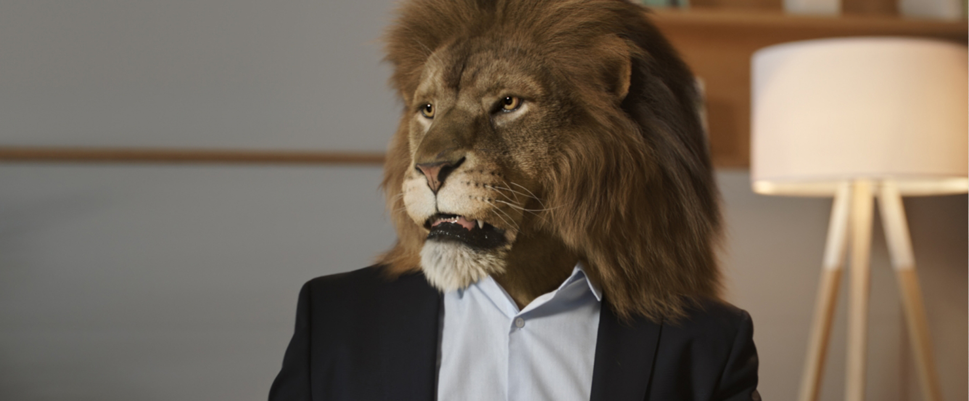 A lion head on a man's body wearing a suit