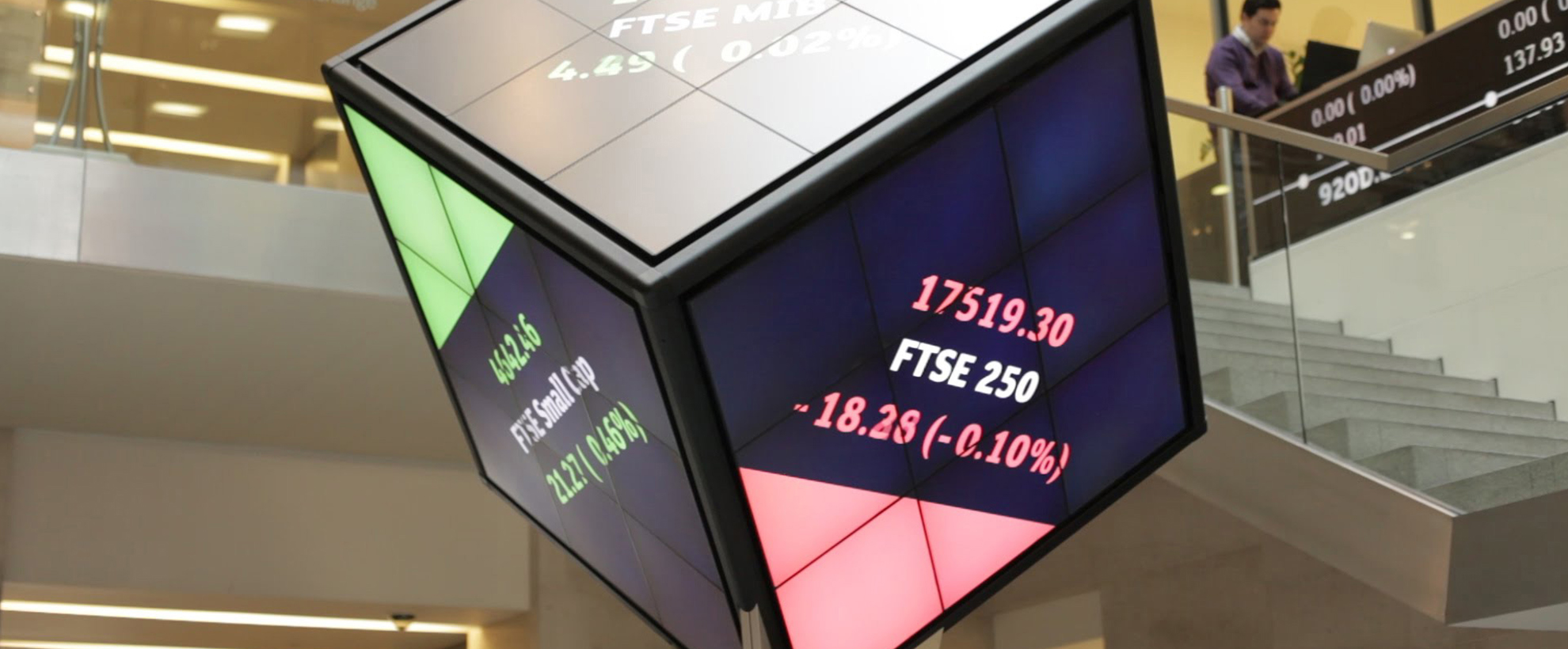 A large cube shaped screen showing different stocks and their positions in the market.