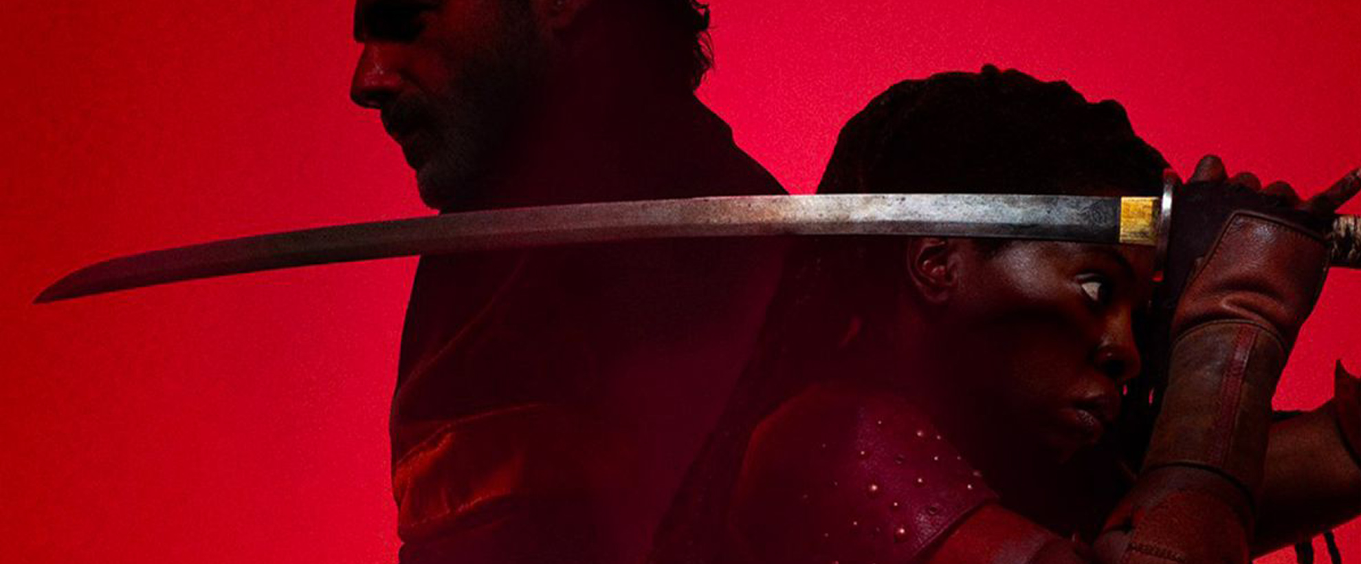 Andrew Lincoln and Danai Gurira stand back to back against a red background, Danai wields a long sword over her shoulder