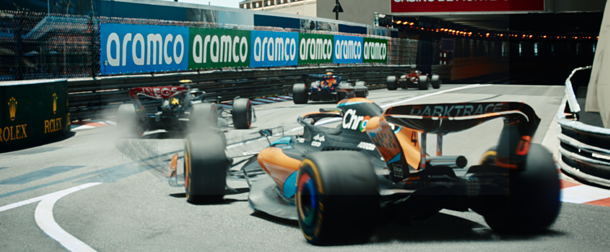 A group of Formula 1 cars are driving through a tunnel. 