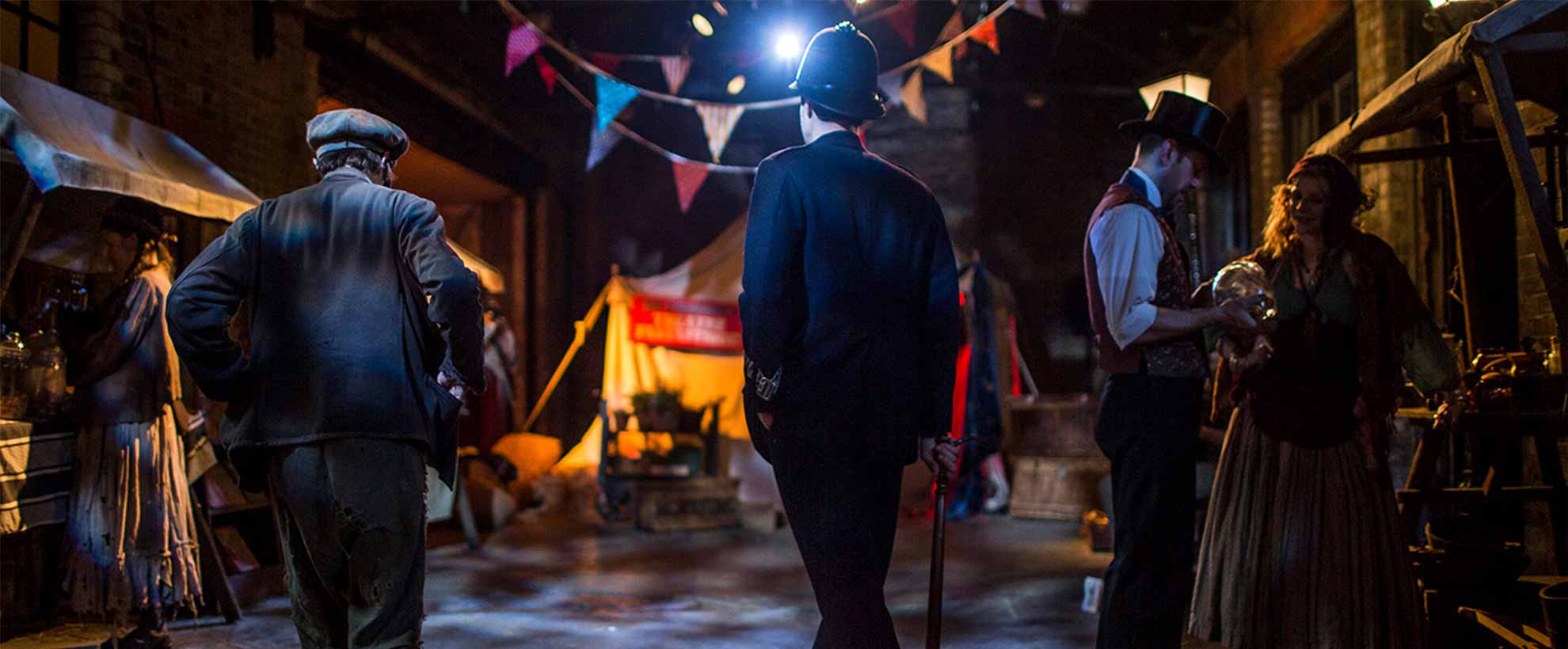 A London street with colourful flags at night time, people in period clothing