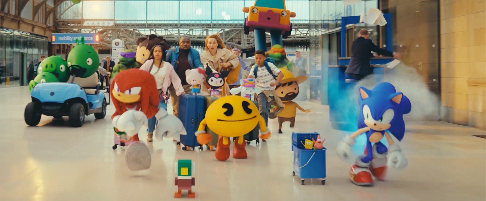 Video game characters like Pac Man and Sonic dash through a train station