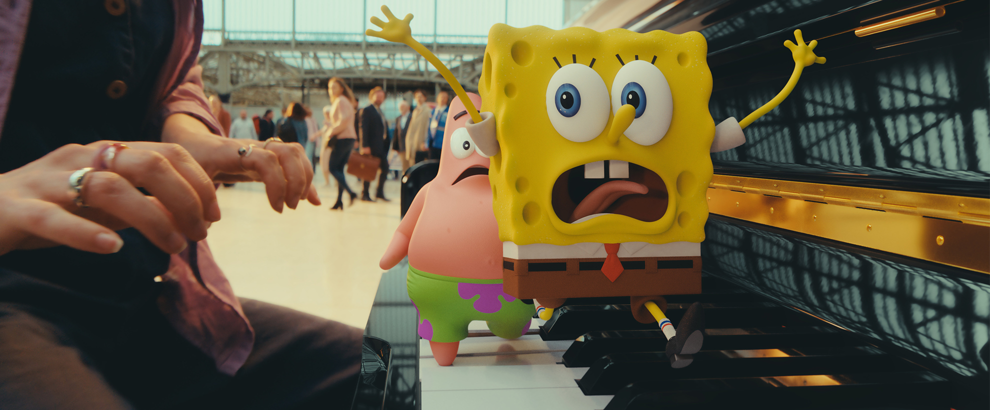CG animated Spongebob Squarepants and Patrick Star run across a piano frantically in a train station