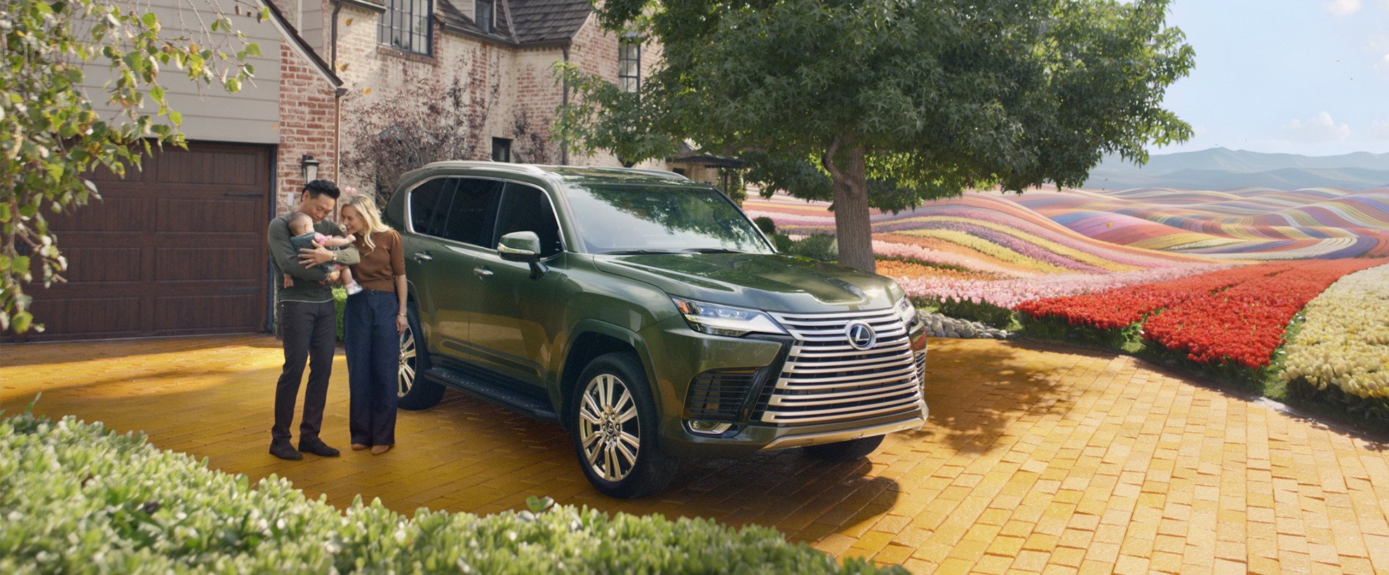 A family stands by a green Lexus SUV; director Jon M. Chu, his wife, and child, near Wicked's iconic flower field.
