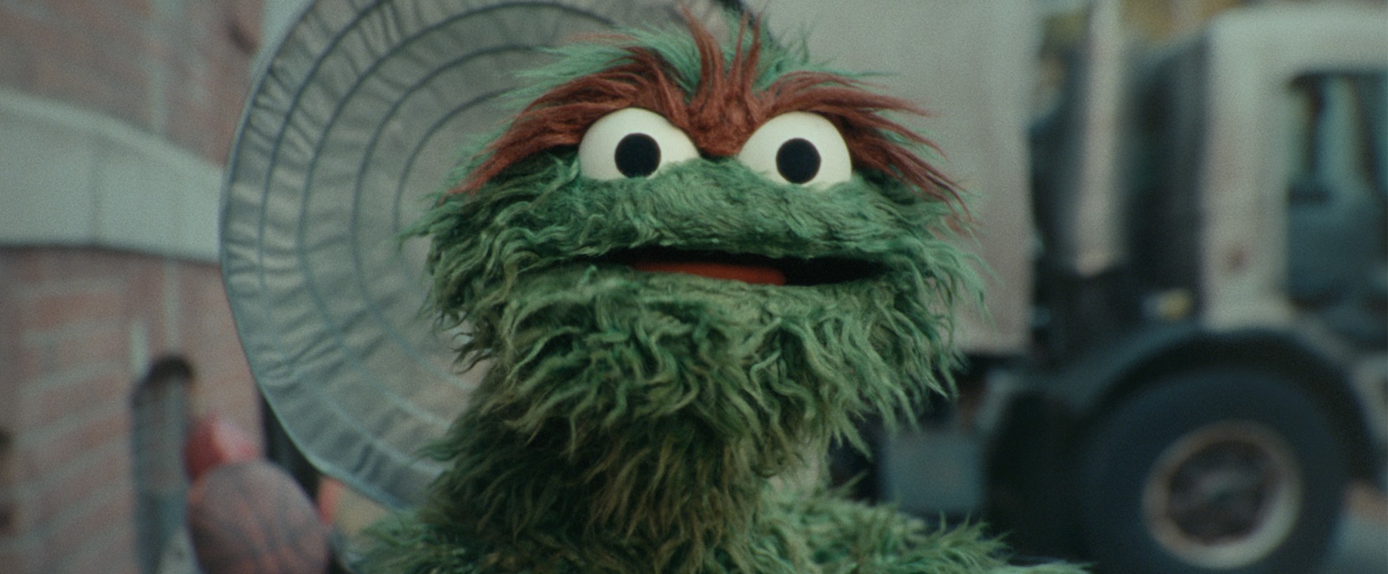 Oscar the Grouch looks onward from his garbage can