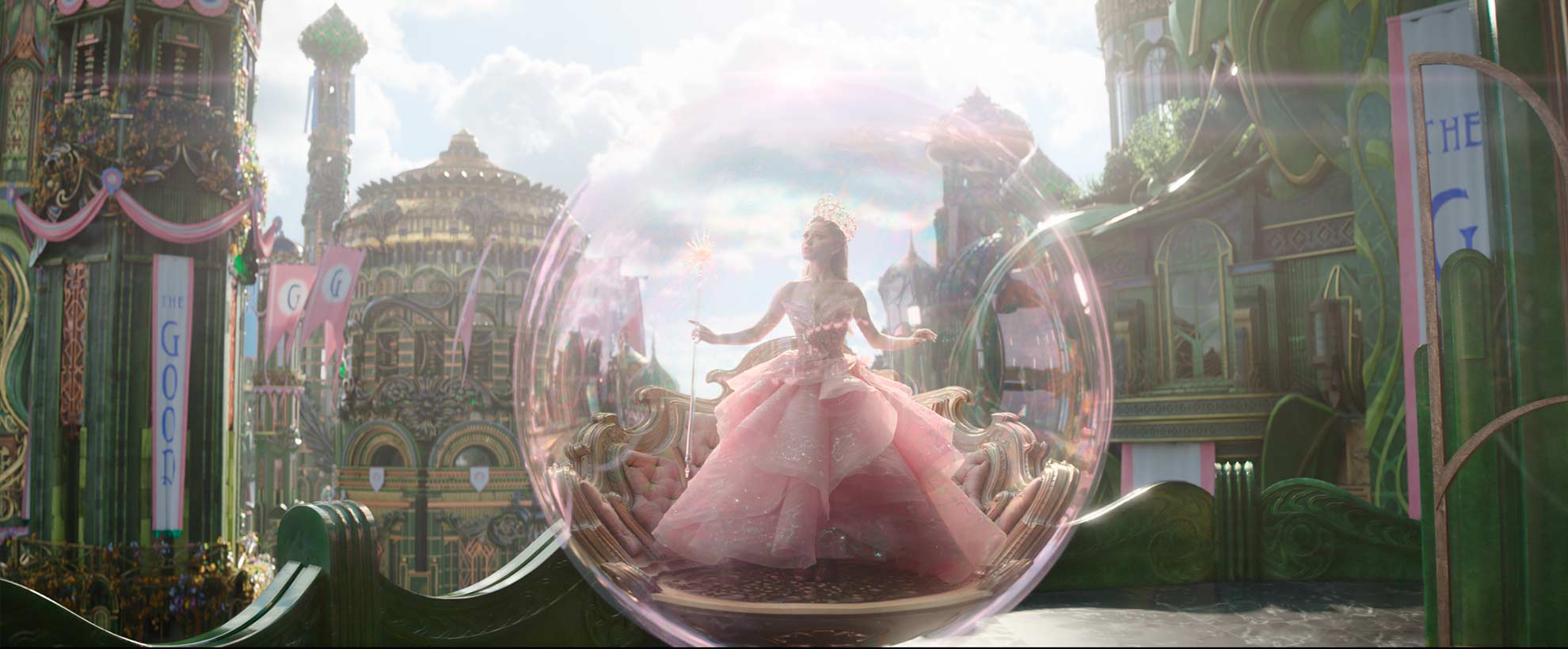 Ariana Grande as Glinda in her pink dress, inside a CGI bubble, surrounded by a digital Emerald City