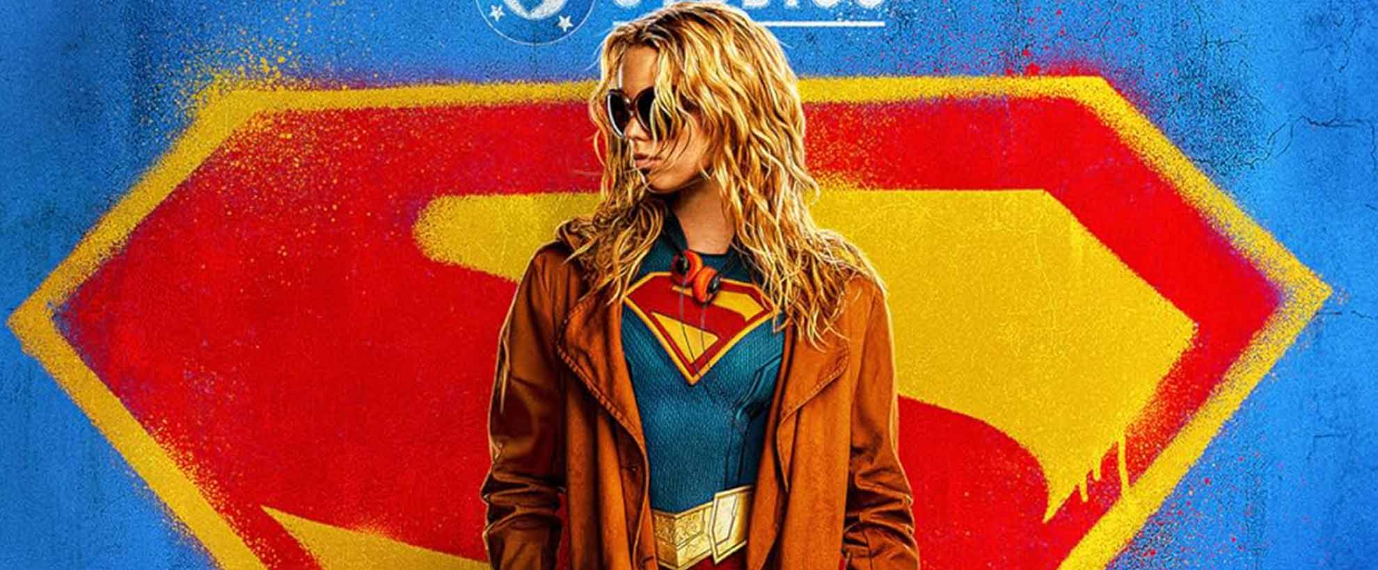 A stylised poster for Supergirl, showing Supergirl standing in front of the S emblem.