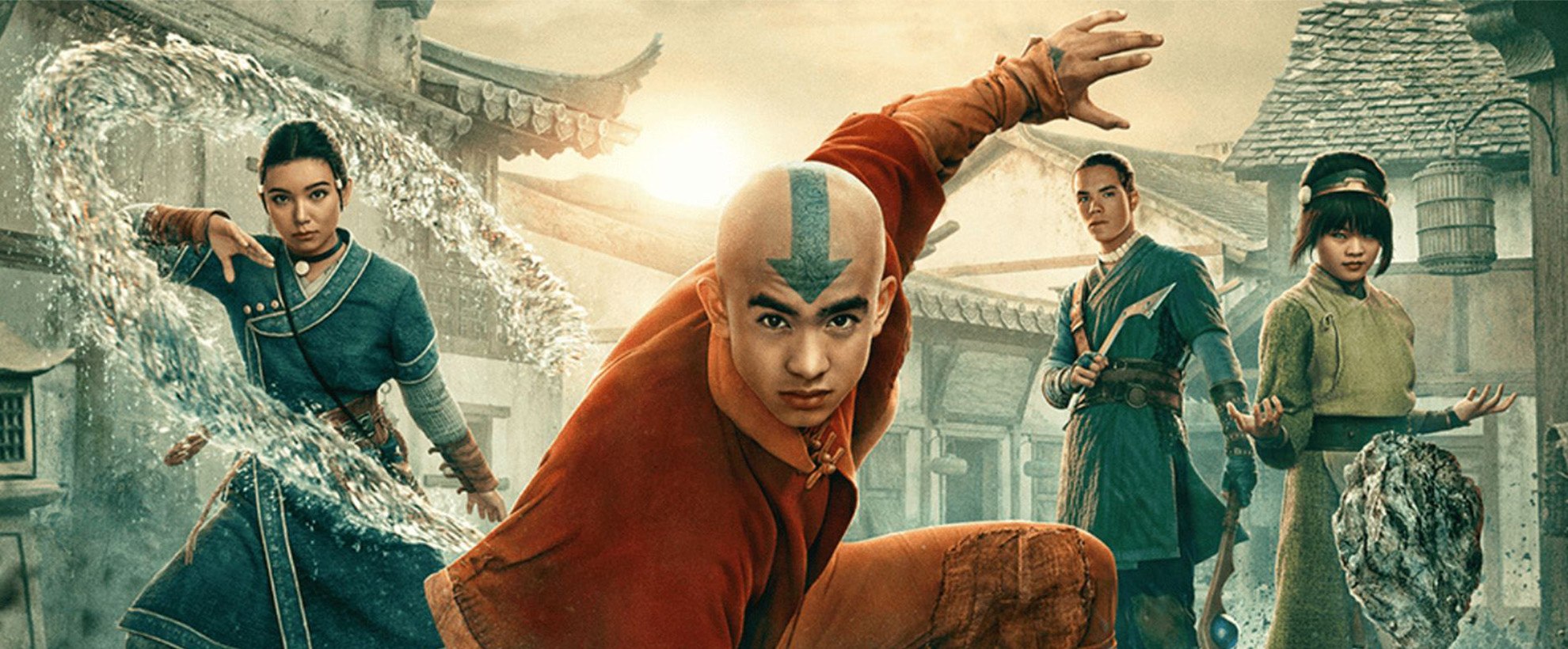 From left to right: Katara, Aang, Saka, and Toph from Avatar: The Last Airbender live action pose in a village, each controlling elements—air, water, earth, and weapons—ready for battle.