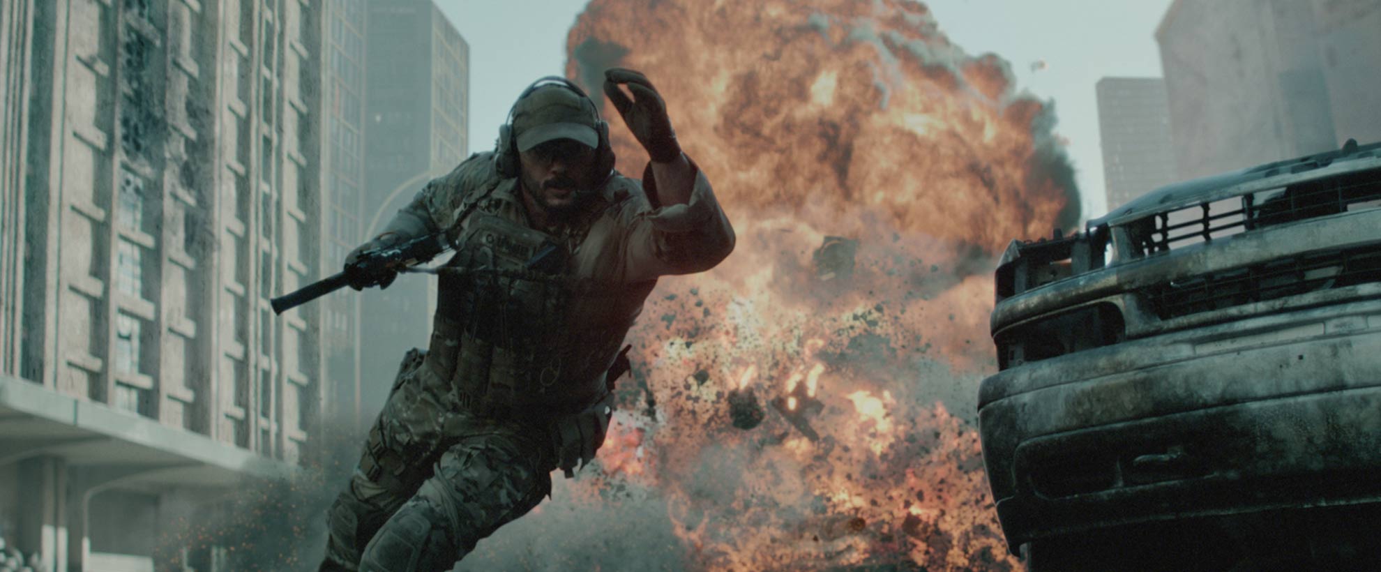 A soldier in tactical gear runs from a massive explosion in a city street, surrounded by CGI debris and damaged vehicles.