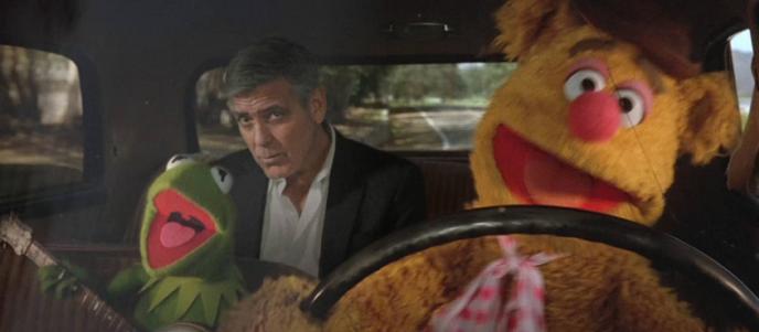 actor george clooney in the backseat of a taxi. the taxi is driven by two muppets characters