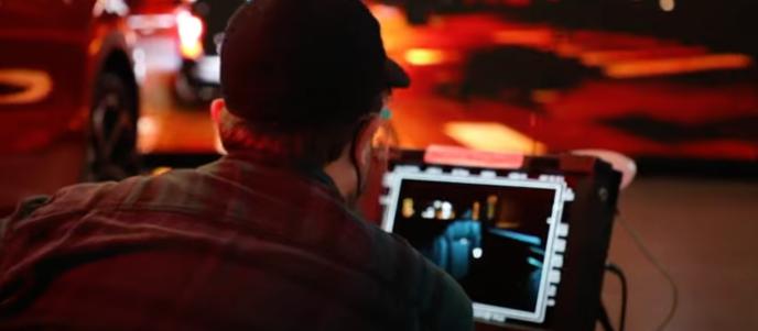 A supervisor watches a monitor on set