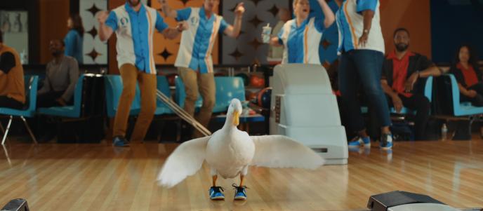 A still from a commercial showing a duck ten pin bowling