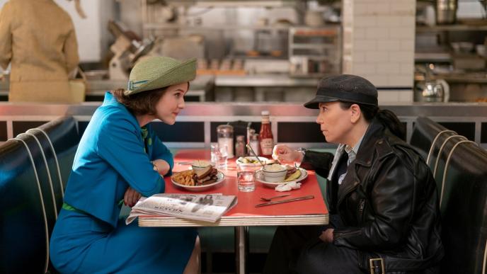 Mrs Maisel sits at a cafe table, facing a young boy