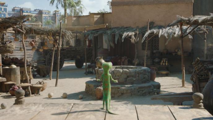back shot of animated gecko character, geico mascot standing in front of a well in a desert city