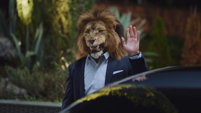 businessperson with the head of a lion waving amongst traffic