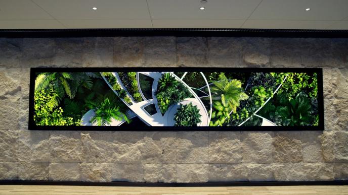 front facing perspective of a screen showcasing greenery that is installed onto a stone wall