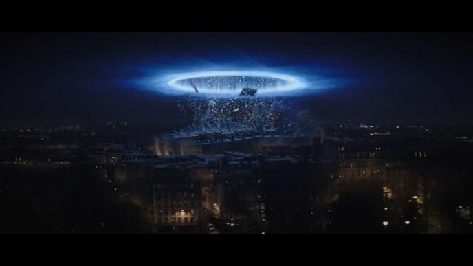 a portal above a large building pulling up particles set in nighttime