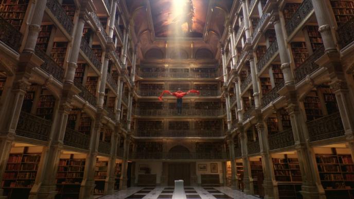 person suspended in air in the centre of a in a six floor library
