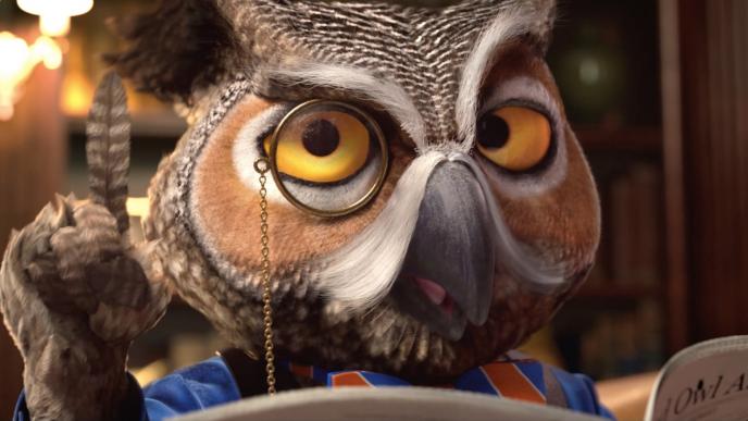 a close up face shot of an animated owl wearing a monocle while holding up a finger