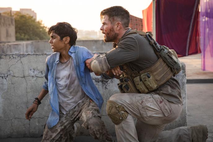 actors rudhraksh jaiswal and chris hemsworth crouching down by a wall