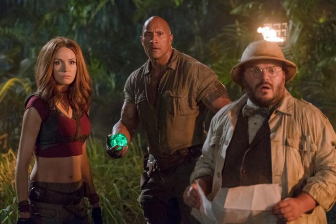 three jumanji characters standing side by side as they look ahead in terror