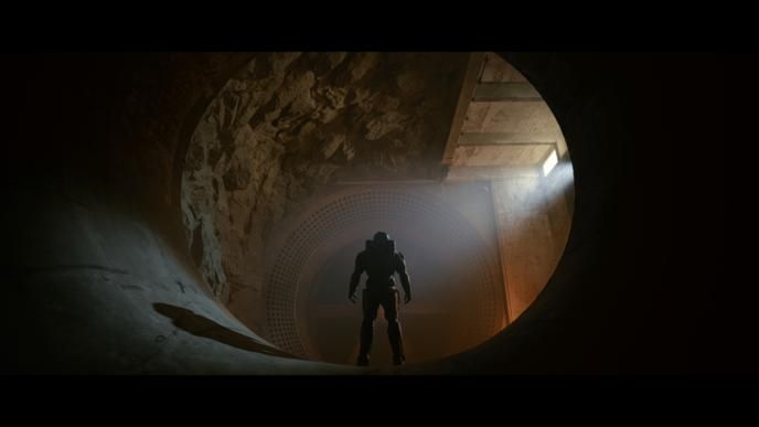 back view of a person in futuristic armor in a tunnel