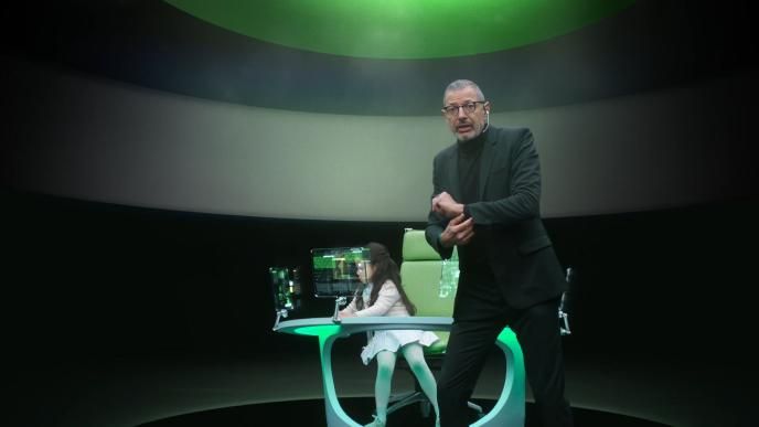 actor jeff goldblum standing in front of a child sitting at a futuristic desk
