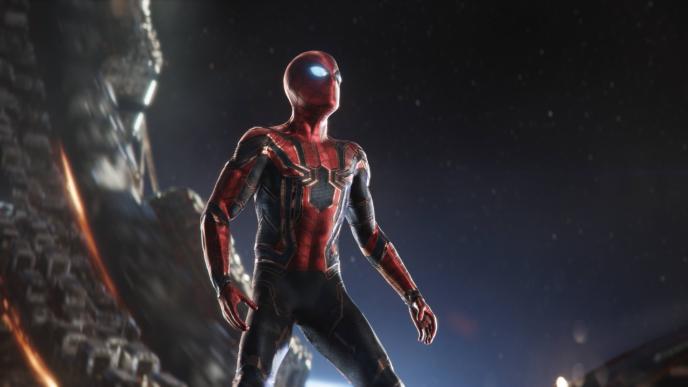 spider-man standing in a q ship wearing the iron spider suit that has a metallic shine