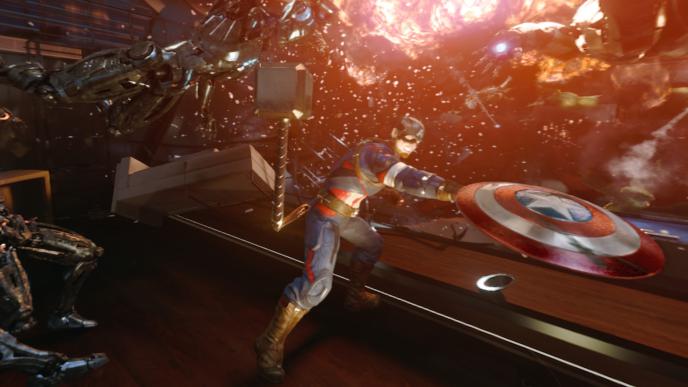 captain america and iron man fighting off robots. thor's hammer is in the centre. there is an explosion in the background