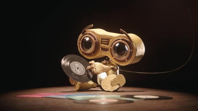 buddy 3000 sitting down holding a miniature record vinyl